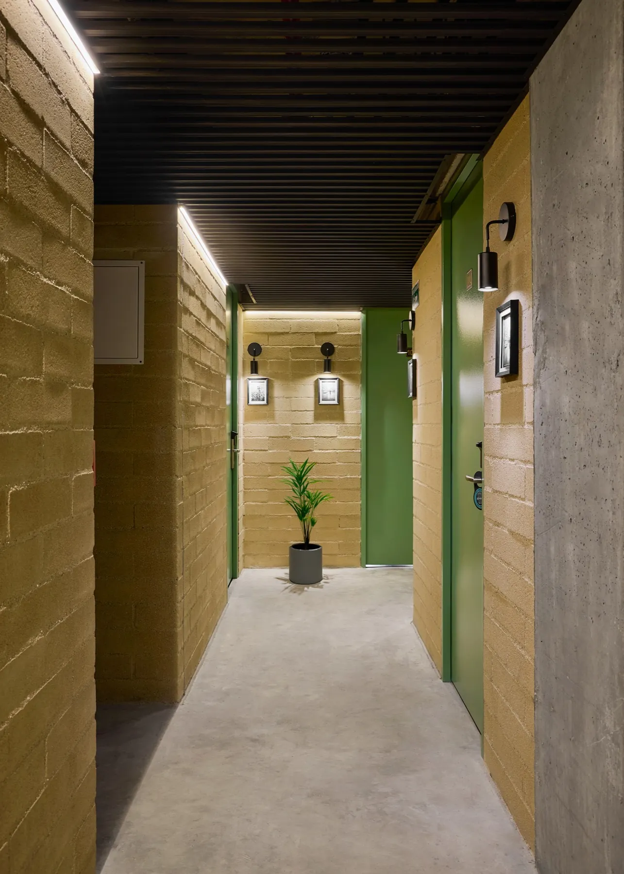 Corredor do URBIT Social Lofts com paredes de concreto aparente
